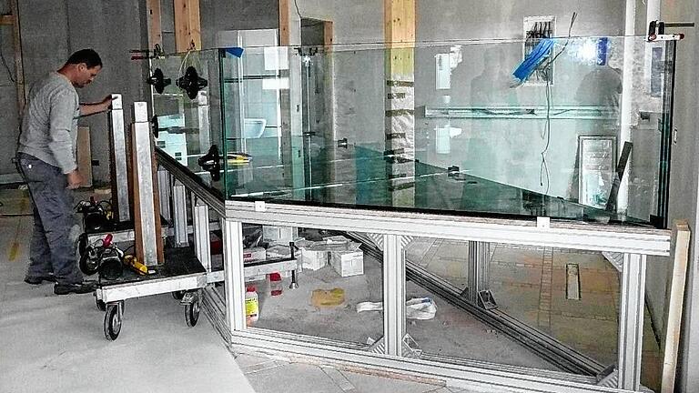 Ralf Geis beim Aufbau eines riesigen Aquariums. Der Unterbau muss stimmen, um die schwergewichtige Konstruktion tragen zu können.