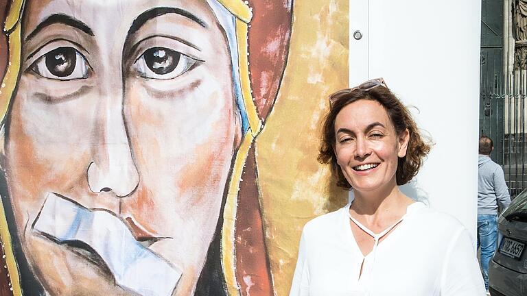 Maria Mesrian, Sprecherin und Aktivistin der Reforminitiative Maria 2.0, neben einem Bild der Muttergottes mit zugeklebtem Mund, gemalt von Lisa Kötter. Maria Mesrian, Sprecherin und Aktivistin der Reforminitiative Maria 2.0, neben einem Bild der Muttergottes mit zugeklebtem Mund, gemalt von Lisa Kötter. 