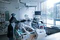 Symbolbild: Mitarbeiterinnen der Pflege in Schutzausrüstung betreut einen Corona-Patienten.