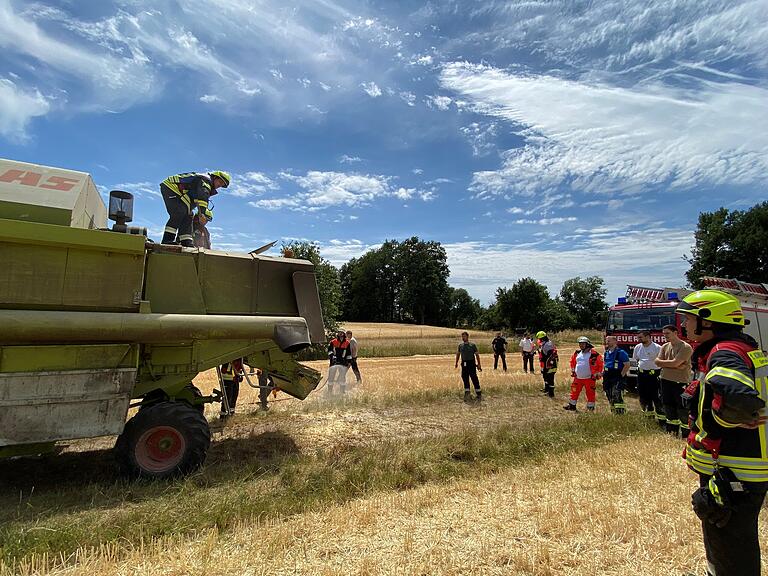 Feuerwehrleute aus Gerolzhofen, Sulzheim und Mönchstockheim beförderten das qualmende Stroh aus der Erntemaschine und löschten Glutnester. Feuerwehrleute aus Gerolzhofen, Sulzheim und Mönchstockheim beförderten das qualmende Stroh aus der Erntemaschine und löschten Glutnester.
