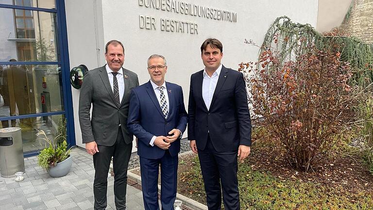 Ralf Michal, Präsident des Bundesverbands Deutscher Bestatter (BDB, von links), Jörg Dittrich, Präsident des Zentralverbands des Deutschen Handwerks (ZDH) und Stephan Neuser (Generalsekretär des BDB) stehen am Eingang des Bundesausbildungszentrums...       -  Ralf Michal, Präsident des Bundesverbands Deutscher Bestatter (BDB, von links), Jörg Dittrich, Präsident des Zentralverbands des Deutschen Handwerks (ZDH) und Stephan Neuser (Generalsekretär des BDB) stehen am Eingang des Bundesausbildungszentrums der Bestatter (BAZ) in Münnerstadt.