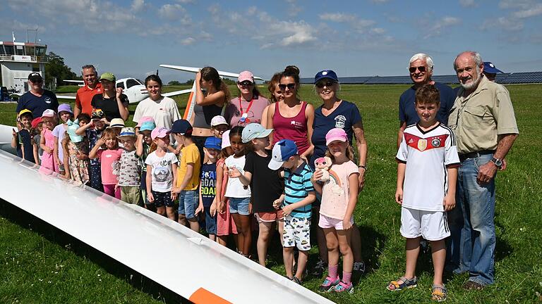 Die Helfer vom FSCW hintere Reihe von rechts nach links Gerd Walz, Ehrenvorsitzender Heinz Gräf und Ljubica Bosnjak-Meyer. Hintere Reihe von links nach rechts die beiden Piloten Mike Hennrich und Wolfgang Meyer. Dazwischen die Betreuerinnen der Sportferienfreizeit am Sanderrasen. 'Dann komme ich in zwei Jahren wieder', rief ein Junge, als ihm Walz vor dem Segelflugzeug erklärte, dass man bereits im Alter von 14 Jahren mit der Schulung für den Segelflugschein beginnen kann.