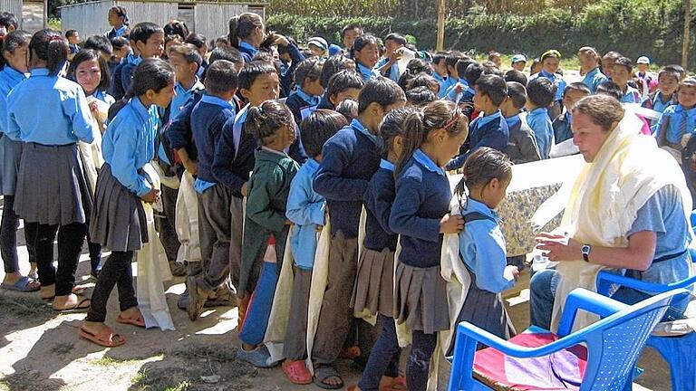 Traditionelle Begrüßung: Kinder in der Schule von Phera übergeben Birgit Kirsch eine Kattha, einen Seidenschal.FOTO: Kirsch