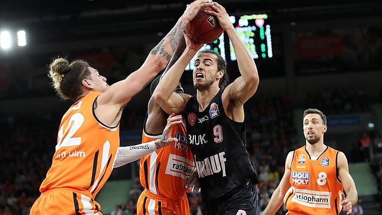 Basketball - easyCredit BBL - ratiopharm ulm - s.Oliver Wuerzburg       -  Bis zum Schluss wurde verbissen um jeden Ball gekämpft, hier nehmen die Ulmer (von links) Isaac Fotu und Javonte Green den Würzburger Xavier Cooks (Nr. 9) in die mangel. Rechts der Ulmer Ismet Akpinar.