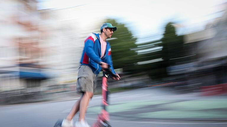 E-Scooter       -  Ein Mann in Hamburg ist auf einem E-Scooter unterwegs. Die Bundesregierung plant neue Regeln zu E-Scootern.