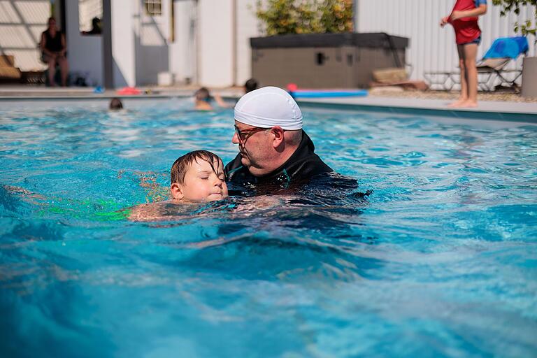 Schwimmlehrer Peter Kröner übt mit dem fünfjährigen Dario das Schwimmen.