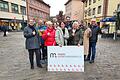 Verantwortliche der Werbegemeinschaft Marktheidenfeld mit der Vorsitzenden Géraldine Barrois (links) auf dem Marktplatz mit dem neuen Logo von 'mein Marktheidenfeld'.