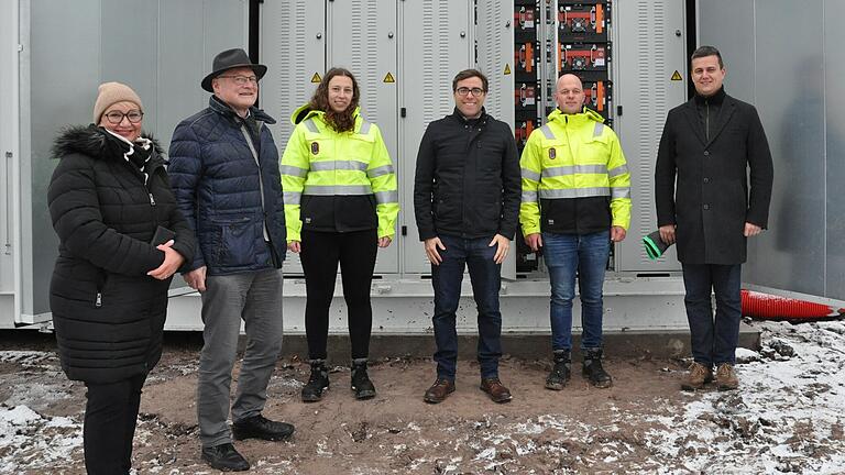 Hofheims Bürgermeister Wolfgang Borst ließ sich über die innovative Stromspeichertechnik von Mitarbeitern der Firmen Max Solar und Egis aufklären. Von links: Judith Klier, Wolfgang Borst, Jennifer Roloff, Egis-Vorstandsvorsitzender Pascal Lang, David Freymark und Christian Mayr vor dem Stromspeicher.