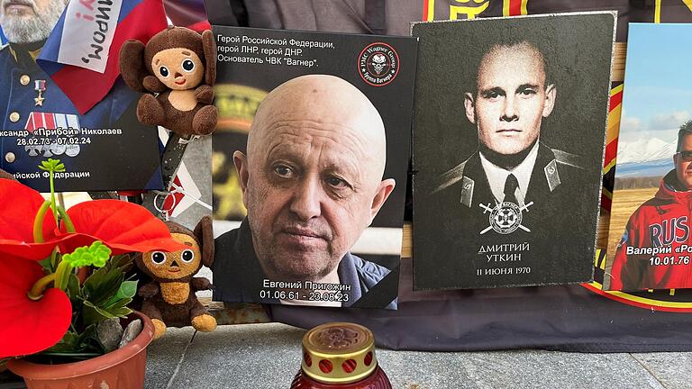 Gedenkstätte       -  An einer impovisierten Gedenkstätte in Kremlnähe erinnern Fotos an die Gründer der russischen Privatarmee Wagner, Jewgeni Prigoschin (l) und Dmitri Utkin.