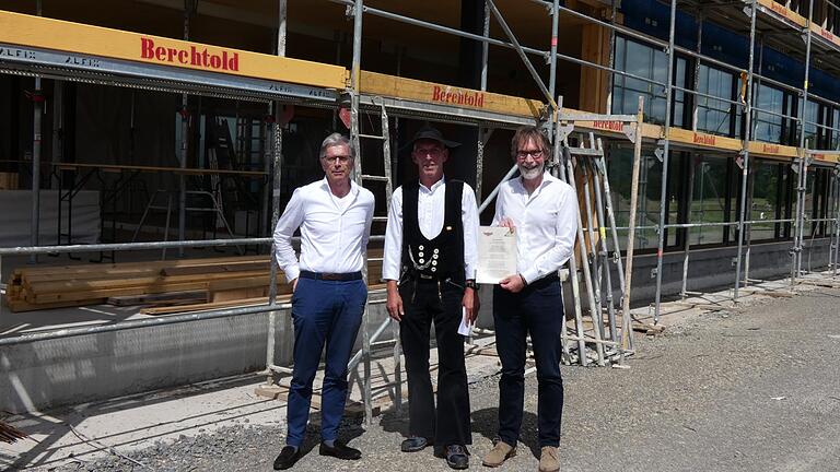 Die beiden geschäftsführenden Gesellschafter der Baur Consult Architekten Ingenieure GbR, Peter Kuhn (links) und Andreas Baur (rechts) freuen sich zusammen mit Zimmermeister Bernhard Aierstock über den Baufortschritt des zukünftig neuen Unternehmenssitzes im Haßfurter Gewerbegebiet Ost.