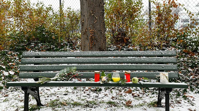 Parkbank vor der Adalberokirche in der Würzburger Sanderau: Sie wurde von Anwohnern in Gedenken an einen vor einigen Tagen verstorbenen Obdachlosen geschmückt.&nbsp;