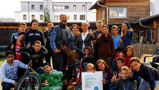 Wir sind spitze! Mitarbeiter und Kinder samt Ziege freuen sich im Hof des Spieli über die Auszeichnung mit dem Phineo-Wirkt-Siegel.