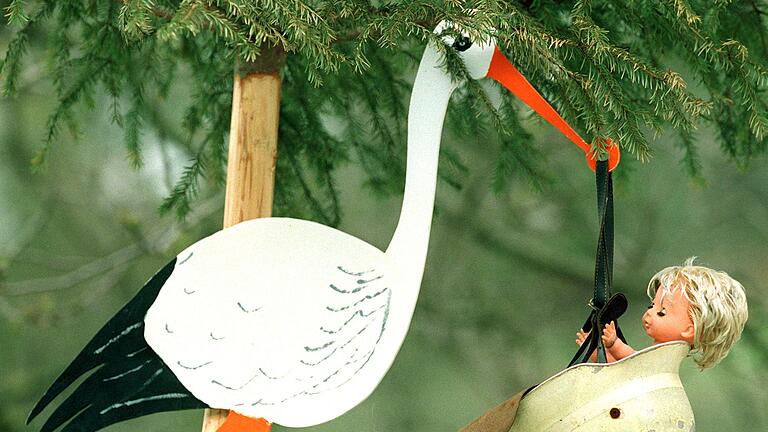 Klapperstorch mit Feuerwehrhelm       -  Im Feuerwehrhelm bringt der Storch im Schwarzwaldort Stegen-Eschbach das Baby, gesehen am Montag (12.04.1999). Freunde des jungen Vaters, Mitglied der freiwilligen Feuerwehr des Ortes, installierten den Klapperstorch mit ausgedientem Helm und Puppe an der Straße vor dem Hof, um Dorfbewohner und Passanten auf den Nachwuchs im Hause aufmerksam zu machen. dpa |