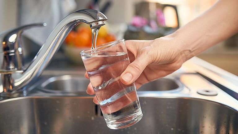 Pouring Fresh Tap Water Into a Glass       -  Akute Gefahr aus dem Wasserhahn: Die Ursache für die Fäkalienkeime im Trinkwasser in Landkreis-Gemeinden von Würzburg und des Main-Spessart-Kreises ist noch nicht gefunden. Mt Chlor will man nun die Bakterien abtöten.