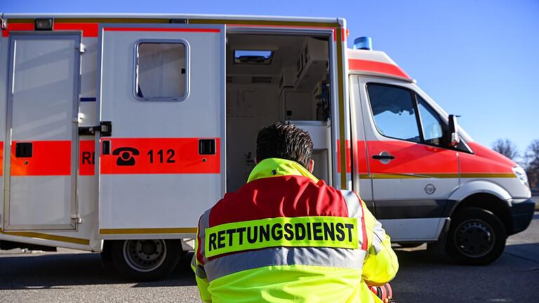 Rettungsdienst       -  &bdquo;Rettungsdienst&rdquo; steht auf der Jacke eines Mannes vor einem Rettungswagen der Feuerwehr. Die Zahl der Rettungsdiensteinsätze ist in den letzten Jahren gestiegen.