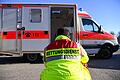 Rettungsdienst       -  &bdquo;Rettungsdienst&rdquo; steht auf der Jacke eines Mannes vor einem Rettungswagen der Feuerwehr. Die Zahl der Rettungsdiensteinsätze ist in den letzten Jahren gestiegen.