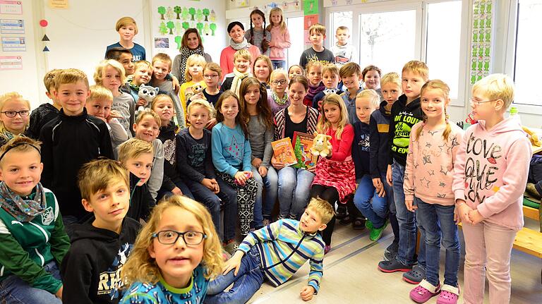Catharina Clas inmitten der Schar der Kinder, die sie mit ihren Geschichten begeistert hat, auch deswegen, weil sie einmal das moderne Medium Alexa Skill eingesetzt hatte. Hinten die beiden Klassenlehrerinnen Jutta Leipold (2. v. l.) und Franziska Weiß.