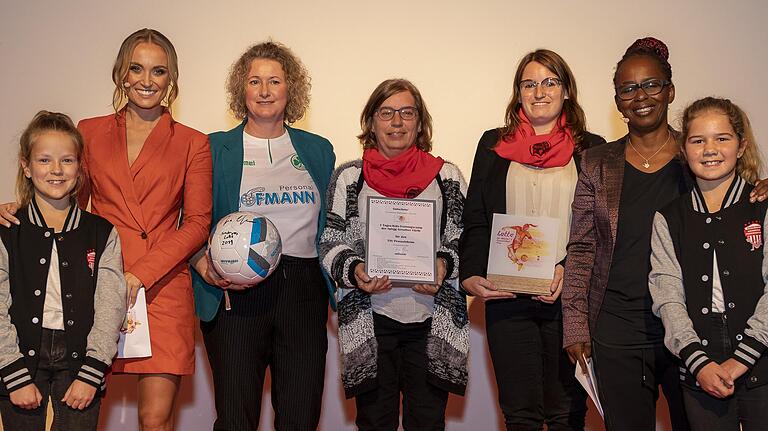 Petra (Mitte) und Hanna Flockerzi (Dritte von rechts) vom TSV Prosselsheim mit den Moderatorinnen Nele Schenker (Zweite von links) und Shary Reeves (Zweite von rechts) sowie Jugendspielerinnen des SC Würzburg. Petra (Mitte) und Hanna Flockerzi (Dritte von rechts) vom TSV Prosselsheim mit den Moderatorinnen Nele Schenker (Zweite von links) und Shary Reeves (Zweite von rechts) sowie Jugendspielerinnen des SC Würzburg.