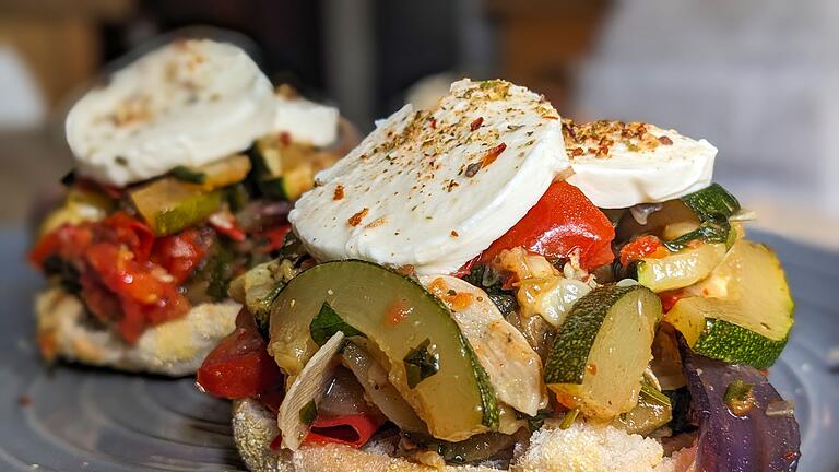 Mediterranes Toastbrötchen       -  Ein Toastie zum Reinbeißen: Auf das Toastbrötchen kommen das angebratene Zucchini-Tomaten-Gemüse sowie Mozzarellascheiben.