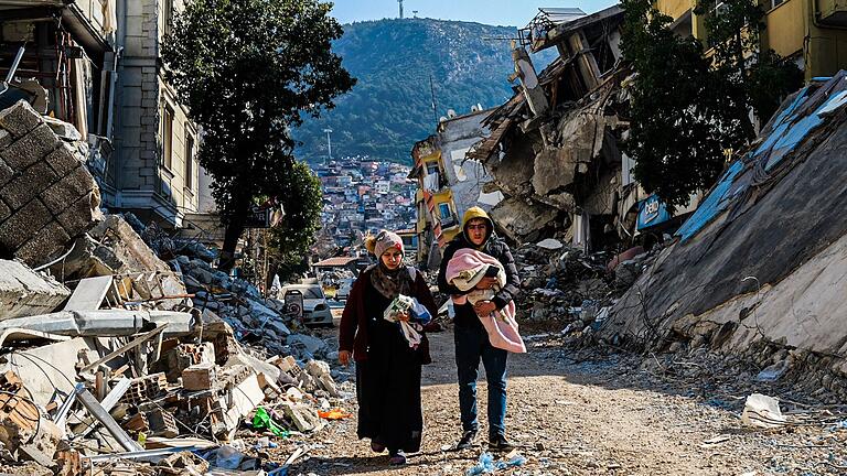 Hatay       -  Eine Frau und ein Mann gehen im türkischen Hatay durch die Trümmer.