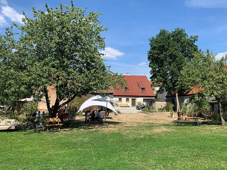 In einem großzügigen Garten mit Streuobstwiese, Permakulturacker, Hühnerställen, Hängematte und vielen Tieren hat Familie Müller ihr Café eingerichtet.