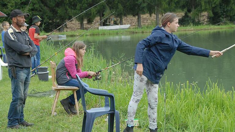 Aufmerksam beobachtet Alfred Senft (links), ob die beiden Geschwister Johanna (Mitte) und Theresa Harzer (rechts) beim Schnupperangeln am Vereinssee der Sportfischer Karlstadt bei Schönarts auch alles richtig machen.