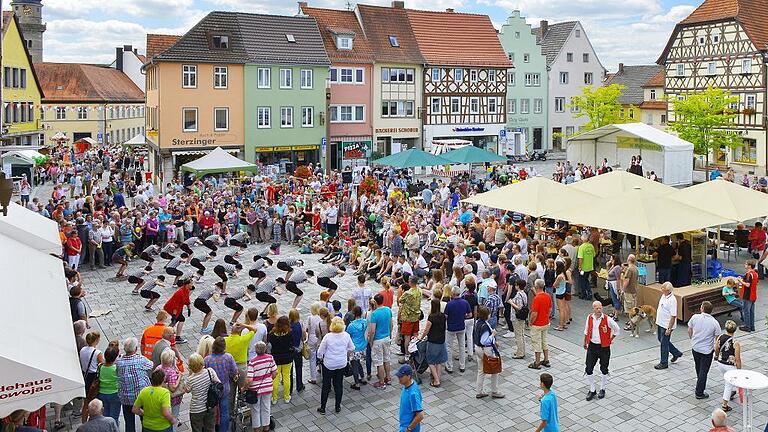 Buntes Stadtfest: Am Mellrichstädter Marktplatz wechselten die Programme häufig. Dem Publikum gefiel es. Im Bild ist die Juniorgarde der MKG zu sehen, die einen Show-Tanz vor einer großen Menge von Zuschauern aufführt.