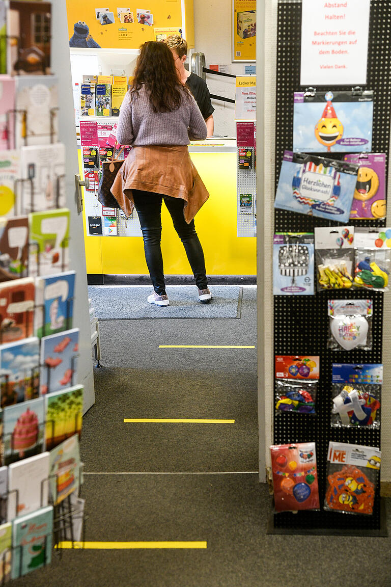 Gelbe Markierungen auf dem Teppichboden in Haas' Laden sollen den Menschen zeigen, wie viel Abstand in der Warteschlange angebracht ist.