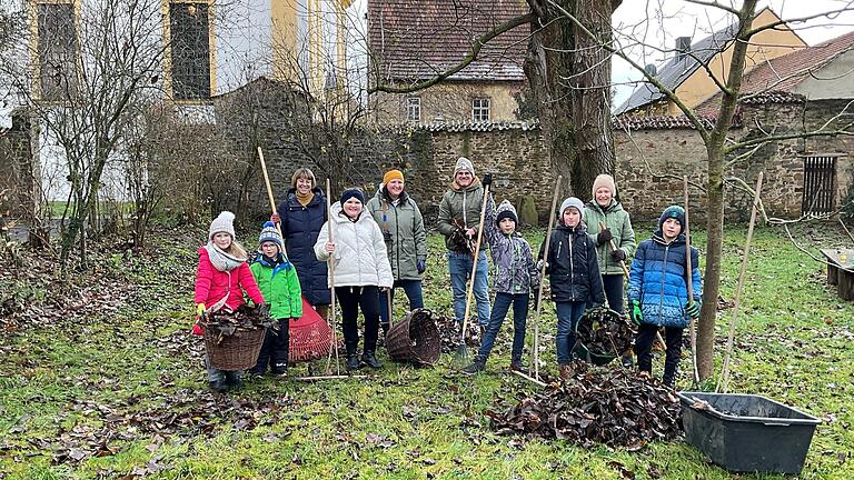 In einer Gemeinschaftsaktion haben sich Kinder mit ihren Eltern im Pfarrgarten zusammengefunden, um das Laub der großen Nussbäume zu beseitigen.