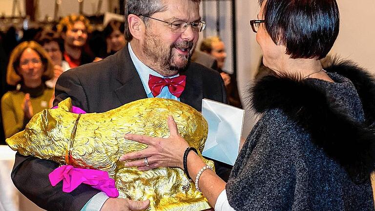 Soll Glück bringen: Marion Rumpel vom Team der Kunsthalle überreichte Erich Schneider ein goldenes Schwein.