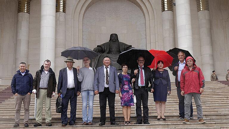 Erstes Treffen in Ulan-Bator: Vertreter der Gemeinden Altanbulag und Schwanfeld vor dem Parlamentsgebäude mit Dschingis Khan-Statue am Sukhbaatar-Platz.