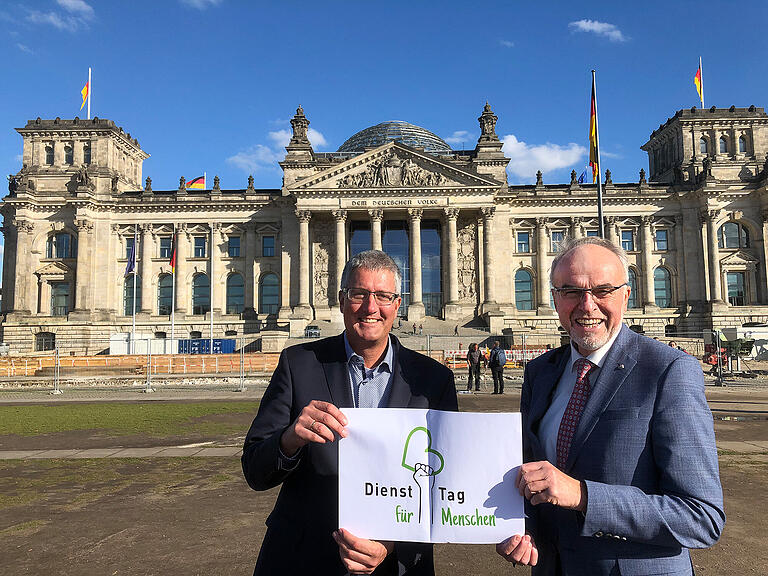 Das Aktionsbündnis 'Dienst-Tag für Menschen' ist in Berlin angekommen: Karsten Eck, Krankenhausdirektor vom König-Ludwig-Haus, und Walter Herberth, Oberpflegamtsdirektor der Stiftung Juliusspital Würzburg vor dem Reichstagsgebäude.