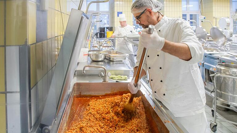 In der Großküche in Würzburg kochen die Mitarbeiterinnen und Mitarbeiter in riesigen Kesseln und schreibtischgroßen Bratpfannen. In der Großküche in Würzburg kochen die Mitarbeiterinnen und Mitarbeiter in riesigen Kesseln und schreibtischgroßen Bratpfannen. 