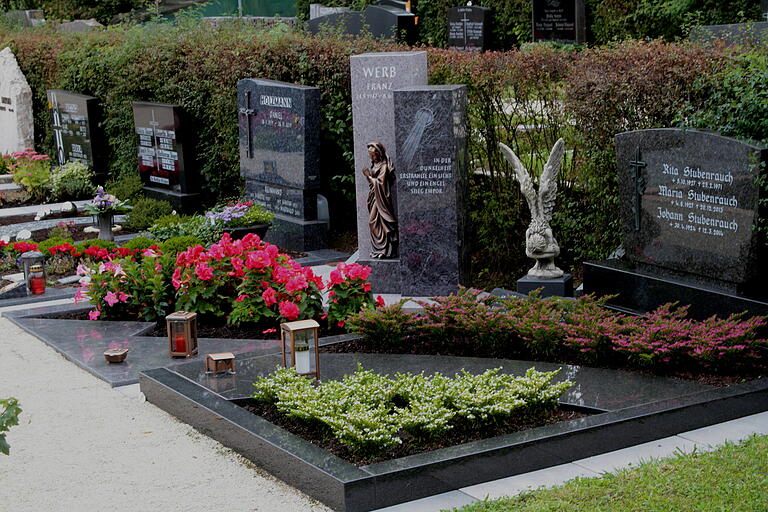 Blick auf die Trends bei den Blumen für Grabbepflanzung: japanische Scheinmyrthe in rosa und weiß (vorne) sowie Feuerkelch (links) und Knollenbegonie auf dem Grab dahinter. Blick auf die Trends bei den Blumen für Grabbepflanzung: japanische Scheinmyrthe in rosa und weiß (vorne) sowie Feuerkelch (links) und Knollenbegonie auf dem Grab dahinter.