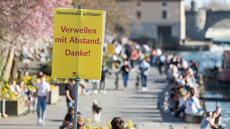 Schilder am Alten Kranen in Würzburg werben für die Einhaltung der Coronaregeln. Wenn die Inzidenz in Stadt und Landkreis weiter unter 100 bleibt, will die Stadt ab 12. April Öffnungsschritte wagen.