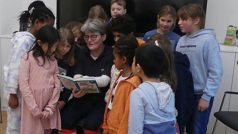 Nachdem Malteserin Christina Gold den Kindern der Jenaplan-Schule aus dem Buch 'Mini muss ins Krankenhaus' vorgelesen hatte, schauten sie sich zusammen noch die lustigen Bilder in dem Buch an.