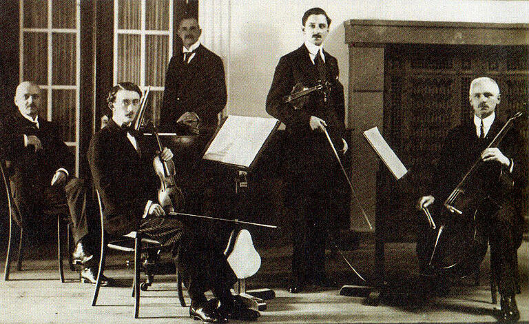 Das Bad Kissinger Salonorchester 1918 vor dem Kamin im Unteren Lesesaal des Regentenbaus: Philipp Schmutzer sitzt links am Klavier. Die Aufnahme stammt ursprünglich vom einstigen Foto-Atelier Carl Schneider in Bad Kissingen.