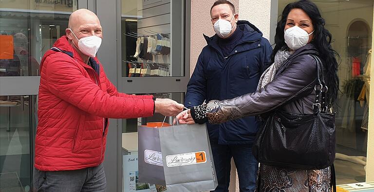 Ralf Ludewig  übergibt Kunden ihre bestellte Kleidung. Das ist dank 'Click and Collect' nun möglich.