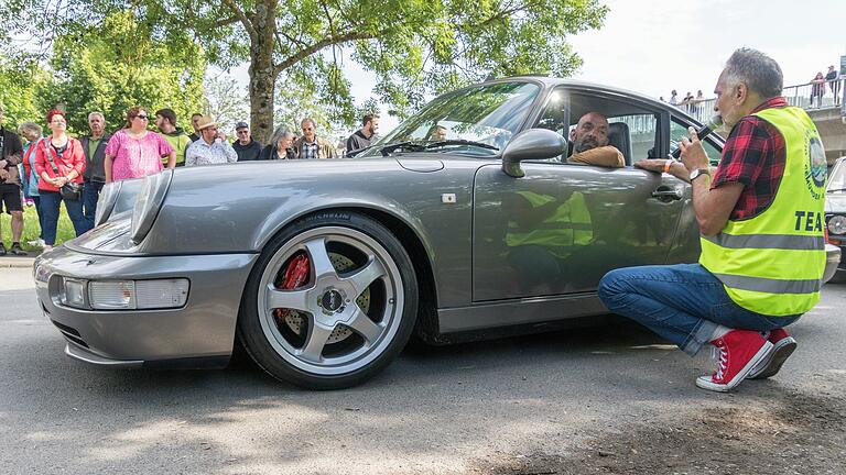 Für Fans von Old- und Youngtimer-Fahrzeugen gab es beim dritten Oldtimertreffen auf der Gemündener Lindenwiese viel zu sehen. Mitorganisator Raimund Eirich (rechts) stellte dem Publikum die Fahrzeuge und ihre Eigenschaften vor. Er verabschiedete am Ende die einzelnen Teilnehmer.