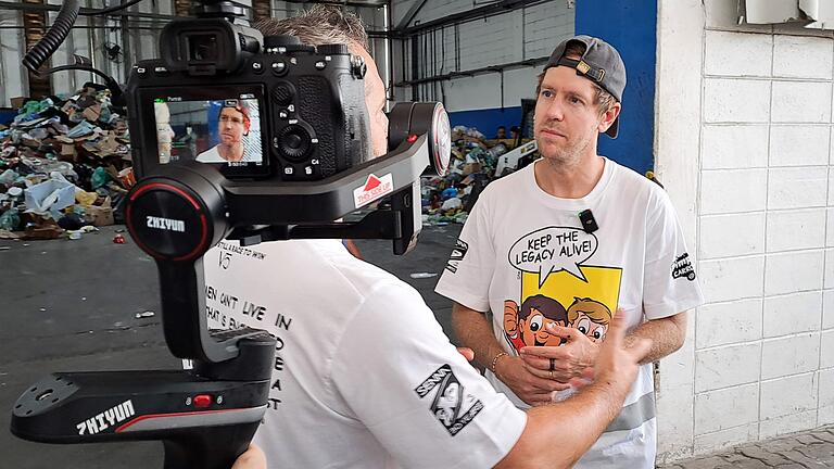 Sebastian Vettel sammelt Müll in Sao Paulo       -  Er erklärt einem TV-Team die Aktion.