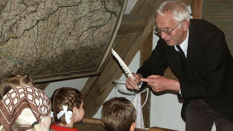 Der gestrenge Dorfschulmeister ist eine Paraderolle von Rudolf Mauder: Der Leiter des Heimatmuseums 'Salzhaus' in Mellrichstadt lässt Geschichte lebendig werden und zeigt Kindern, wie früher mit Gänsefedern geschrieben wurde.&nbsp;&nbsp;