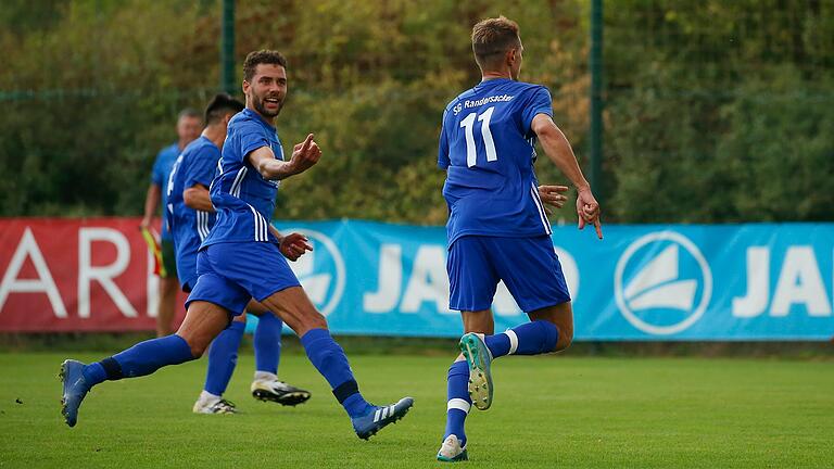 Jeffrey Karl (links) und Jens Müller jubeln. Beide haben zusammen fast zwei Drittel der bisherigen Tore der SG Randersacker erzielt. Karl führt seine Mitspieler in den letzten sieben Kreisliga-Spielen auf dem Platz, unterstützt von Thomas Hess an der Seitenlinie.