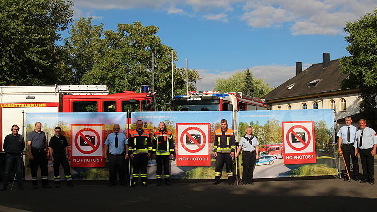 Fotograf Berthold Diem (links) spendete den Feuerwehren Schutzwände gegen Gaffer. Im Bild Kommandanten und Verantwortiche der Feuerwehren aus Hettstadt, Helmstadt, Waldbrunn und Waldbüttelbrunn. Foto: Traudl Baumeister