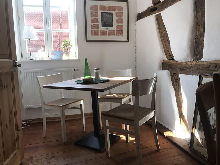 Doch auch ruhige Ecken mit kleinen Tischen hat das Café zu bieten. An der Wand dahinter zeigen Bilder, wie das Haus früher ausgesehen hat. Doch auch ruhige Ecken mit kleinen Tischen hat das Café zu bieten. An der Wand dahinter zeigen Bilder, wie das Haus früher ausgesehen hat.