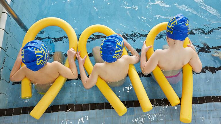 Kinder sitzen beim Schwimmunterricht im Wasser. Seit der Pandemie finden in Bayern keine Schwimmkurse mehr statt, die Termine sind zum Teil auf Jahre ausgebucht.