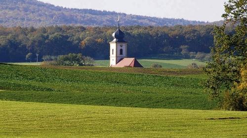 Die Ansicht des Dornheimer Kirchturms, der aus dem sanft gewellten Steigerwaldvorland ragt, erscheint vielen als Idylle. Iphofens Bürgermeister Josef Mend mag da anders empfinden. Denn die Bürgerversammlungen dort werden für ihn zu verbalen Kraftakten.