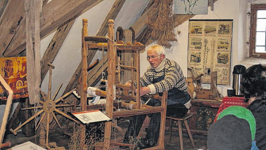 Emsiger Weberknecht: Letzter Arbeitsschritt bei der Stoffherstellung war das Weben. Rudolf Mauder zeigt an einem Bandwebstuhl, wie es geht. Die Maße lassen darauf schließen, dass damit früher Kinder gearbeitet haben.