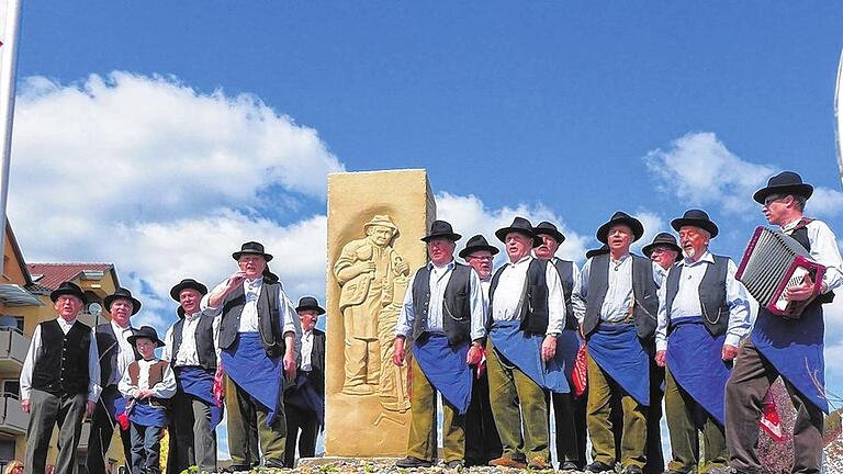 Das Werk ist fertig: Mit dem Zeiler Steinhauerlied weihten die Vereinsmitglieder den Kreisel auf ihre Weise ein.  Links im Bild: Heinrich Weisel und drei Generationen der Familie Brecht, rechts weitere Mitglieder des Steinhauervereins.