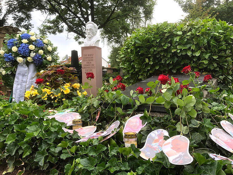 Die Gäste legten zum Abschluss der Veranstaltung rote Rosen am Grab nieder. An jede Rose war ein Foto in Form einer Fußspur gebunden, auf dem eine Szene aus dem Alltag in den Blindeninstituten zu sehen war.