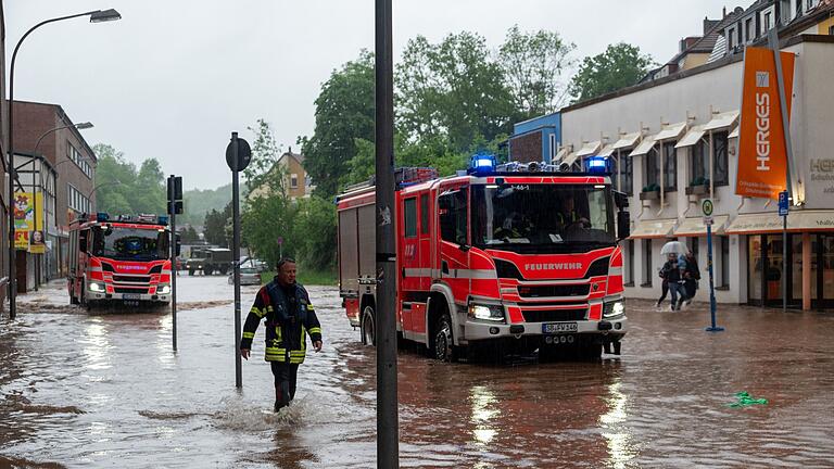 Überschwemmungen in Saarbrücken.jpeg       -  Feuerwehrleute bewegen sich durch das Hochwasser in Saarbrücken.